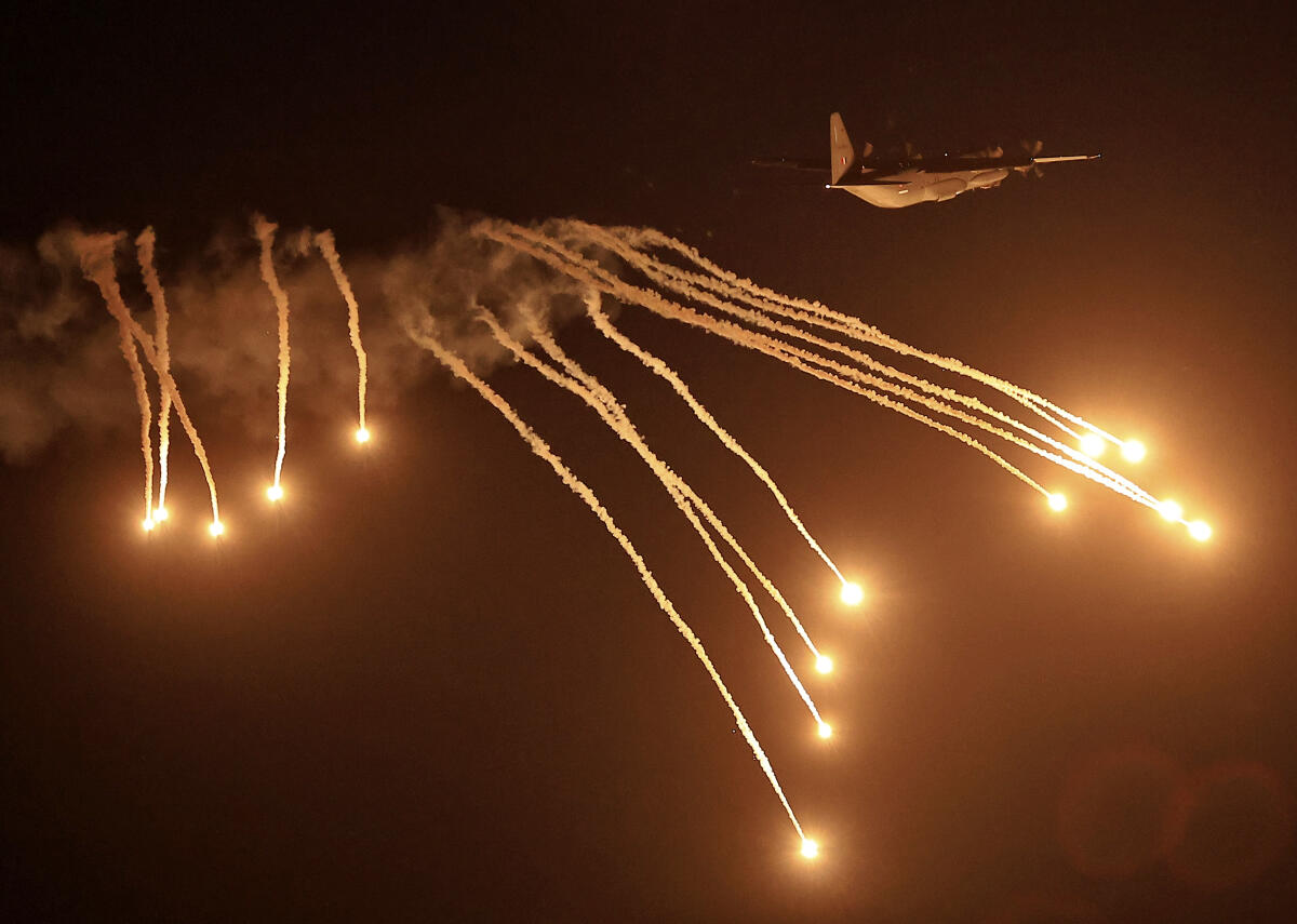 An Indian Air Force (IAF) aircraft releases flares during a demonstration as part of Exercise 'Vayu Shakti' at the Pokharan Field Firing Range