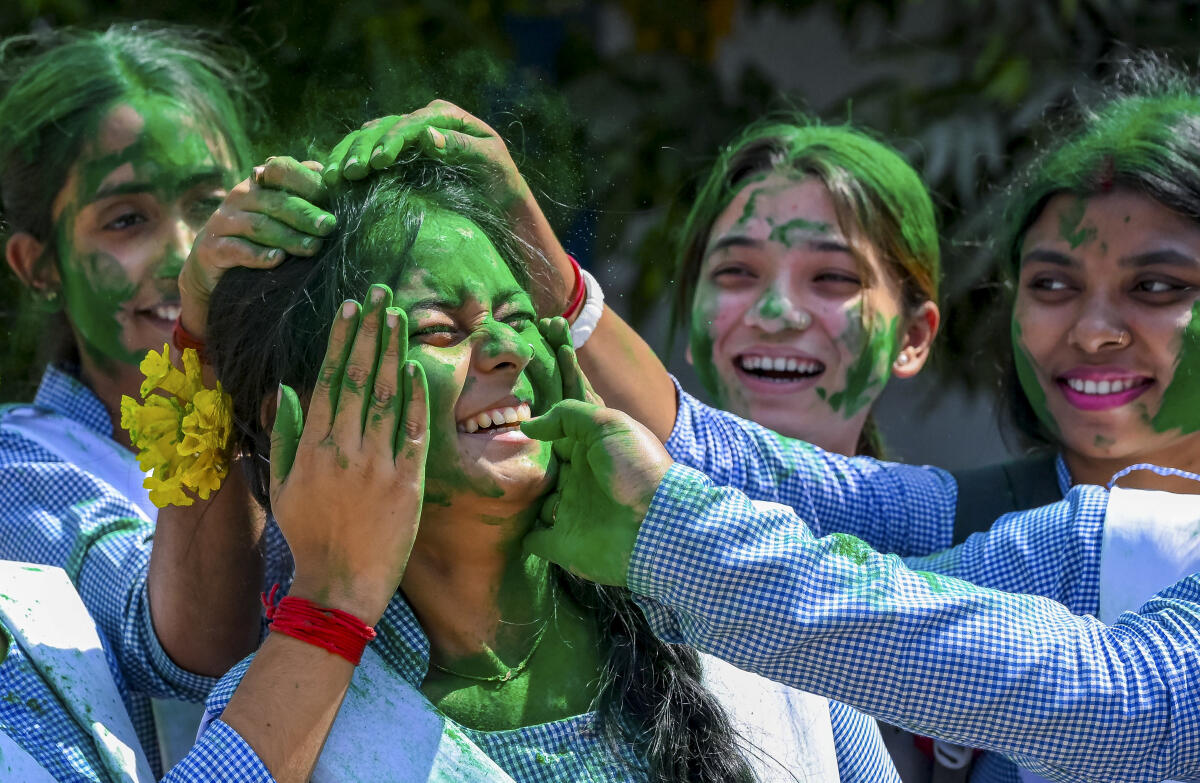 Students play with 'gulal' after appearing for Higher secondary examination, ahead of the Holi festival, in Nadia, West Bengal