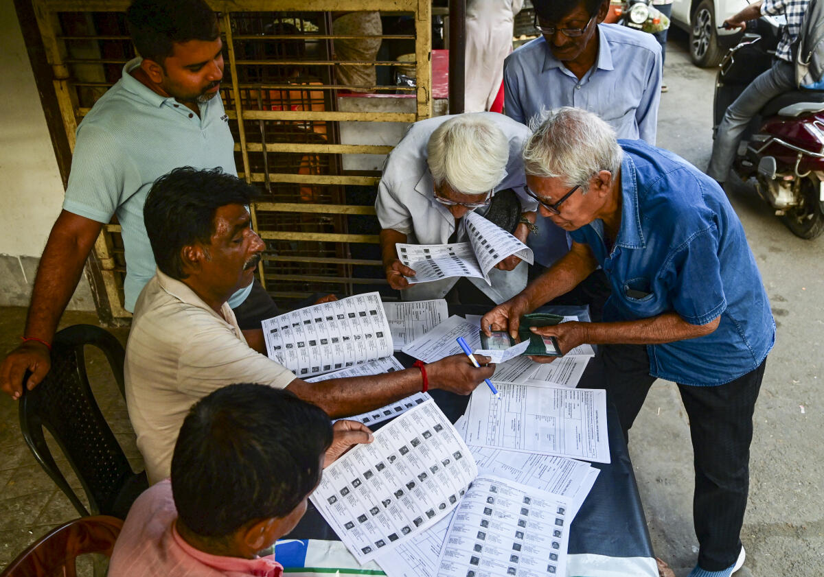 Voters check their names in the list after the Election Commission published West Bengal's post-SIR electoral rolls, in Kolkata