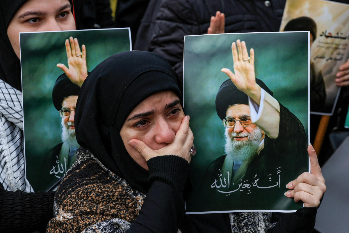 A woman reacts as she holds a placard with an image of Iranian late Supreme Leader Ayatollah Ali Khamenei, at a rally in solidarity with Iran after US and Israeli strikes killed Ali Khamenei
