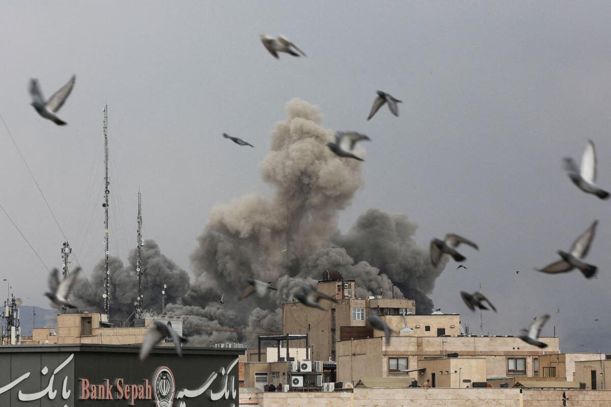 Birds fly as smoke rises following an explosion, after Israel and the US launched strikes on Iran, amid the US-Israel conflict with Iran