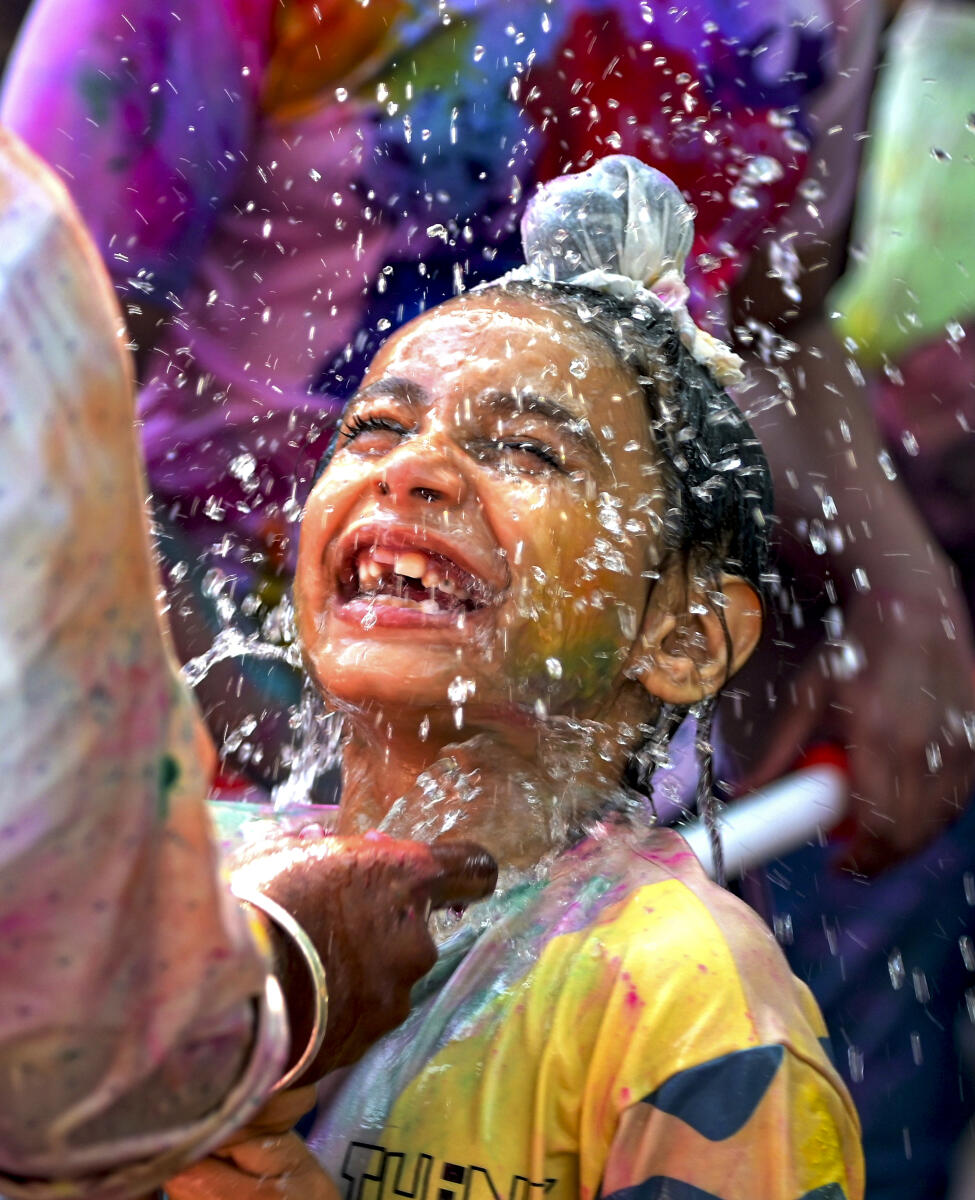 A child reacts as water is splashed during a Holi celebration programme organised by 'Prayas School for Children with Special Needs', in Nagpur