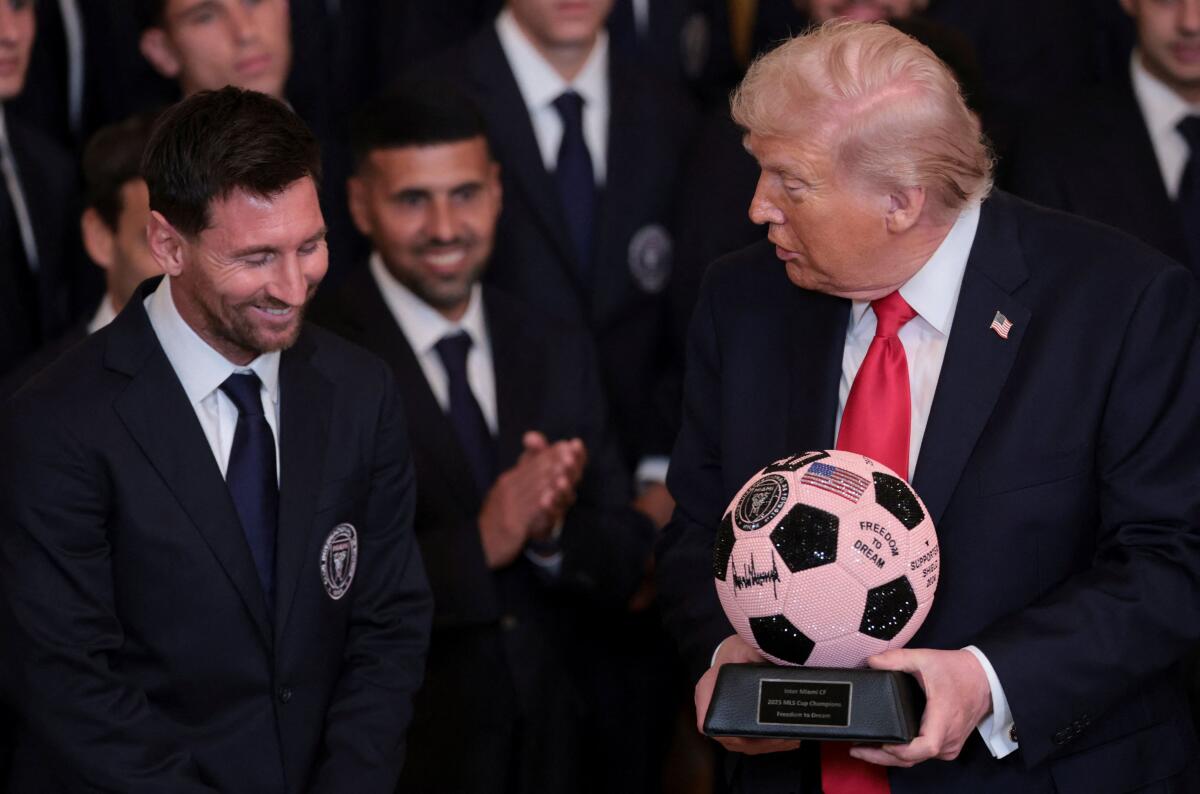 Inter Miami CF captain Lionel Messi reacts as U.S. President Donald Trump holds a jeweled soccer ball with his signature on it that was gifted to him as he honors reigning Major League Soccer (MLS) champion Inter Miami CF players and team officials with an event in the East Room of the White House in Washington, D.C. Reuters 