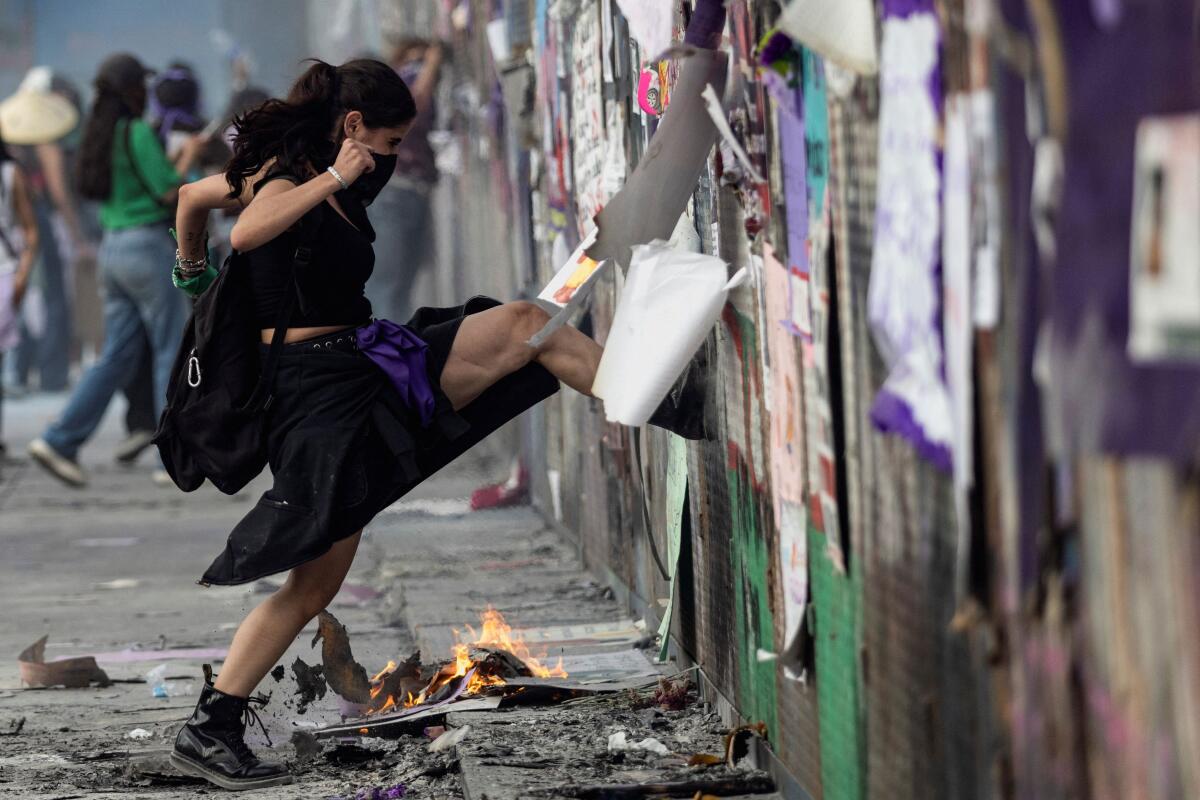 A demonstrator hits a barrier erected in front of the National Palace in Zocalo Square during a protest to mark International Women's Day, in Mexico City, Mexico.