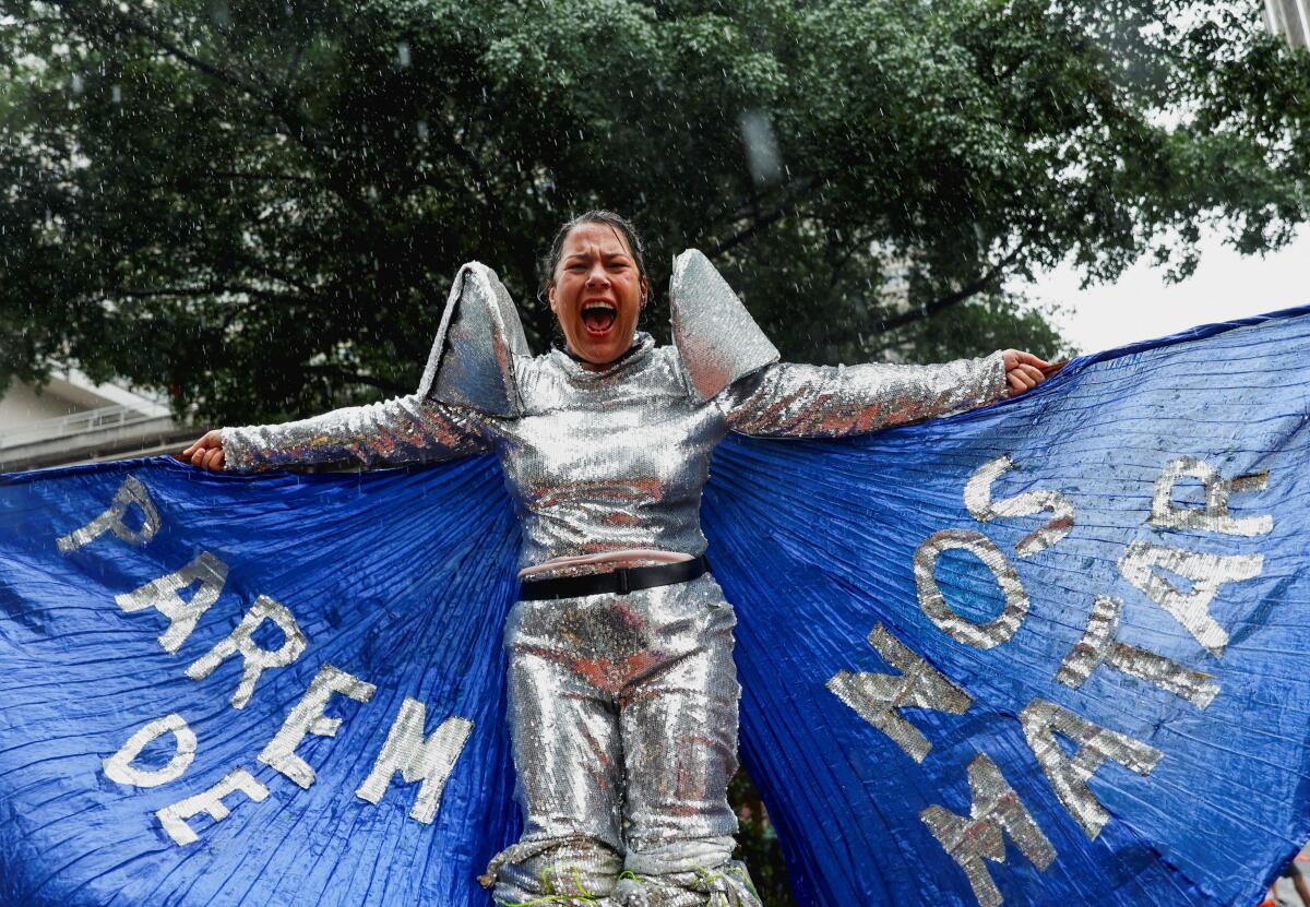 A woman wears a suit reading "Stop killing us" during a march to mark International Women's Day, in Sao Paulo, Brazil.
