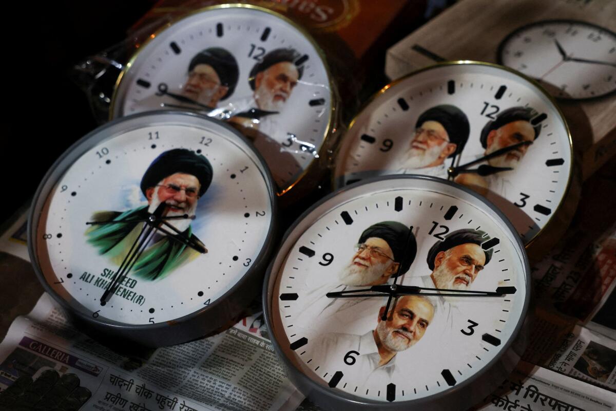 Wall clocks with images of the late Iranian Supreme Leader Ayatollah Ali Khamenei displayed for sale outside a mosque in New Delhi.