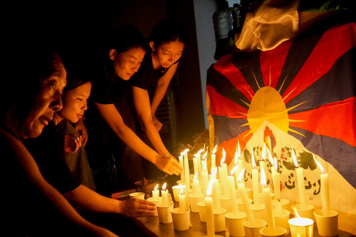 People light candles during a prayer meet and candlelight vigil to mark the 67th anniversary of the Tibetan National Uprising Day, in Chennai.