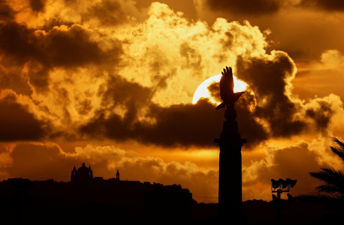 The sun sets behind the Malta Memorial, often referred to as the Commonwealth Air Forces Memorial, in Floriana, Malta, March 13, 2026.