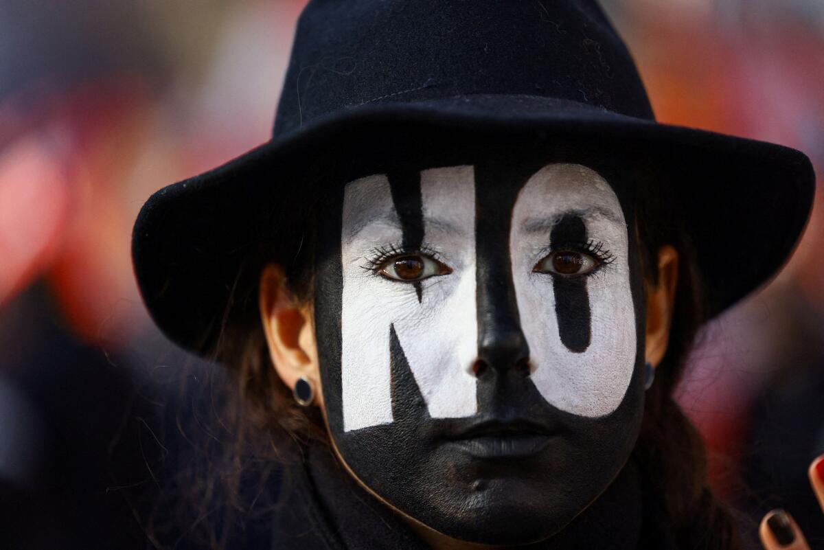 A demonstrator with the word "No" painted across their face takes part in a protest supporting the "No" campaign ahead of Italy’s March 22–23 referendum on judicial reform and criticising the government of Prime Minister Giorgia Meloni’s foreign policies, in Rome, Italy, March 14, 2026.