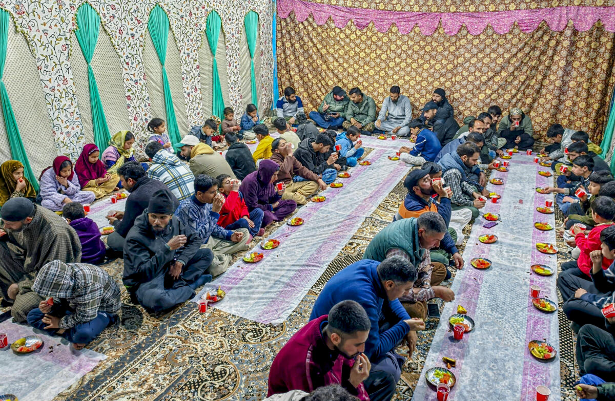 People gather during ‘iftar’ and dinner organized by the Indian Army's 50 RR, Pampore, Jammu and Kashmir, Sunday, March 15, 2026.