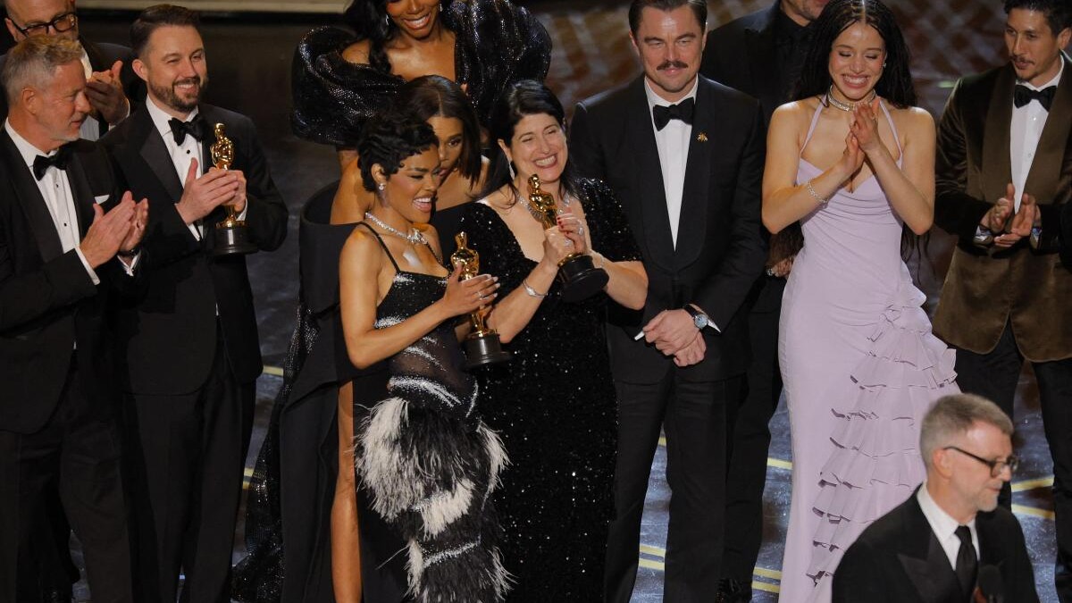 Cast members listen as director Paul Thomas Anderson accepts the Oscar for Best Picture for One Battle after Another during the Oscars show at the 98th Academy Awards.
