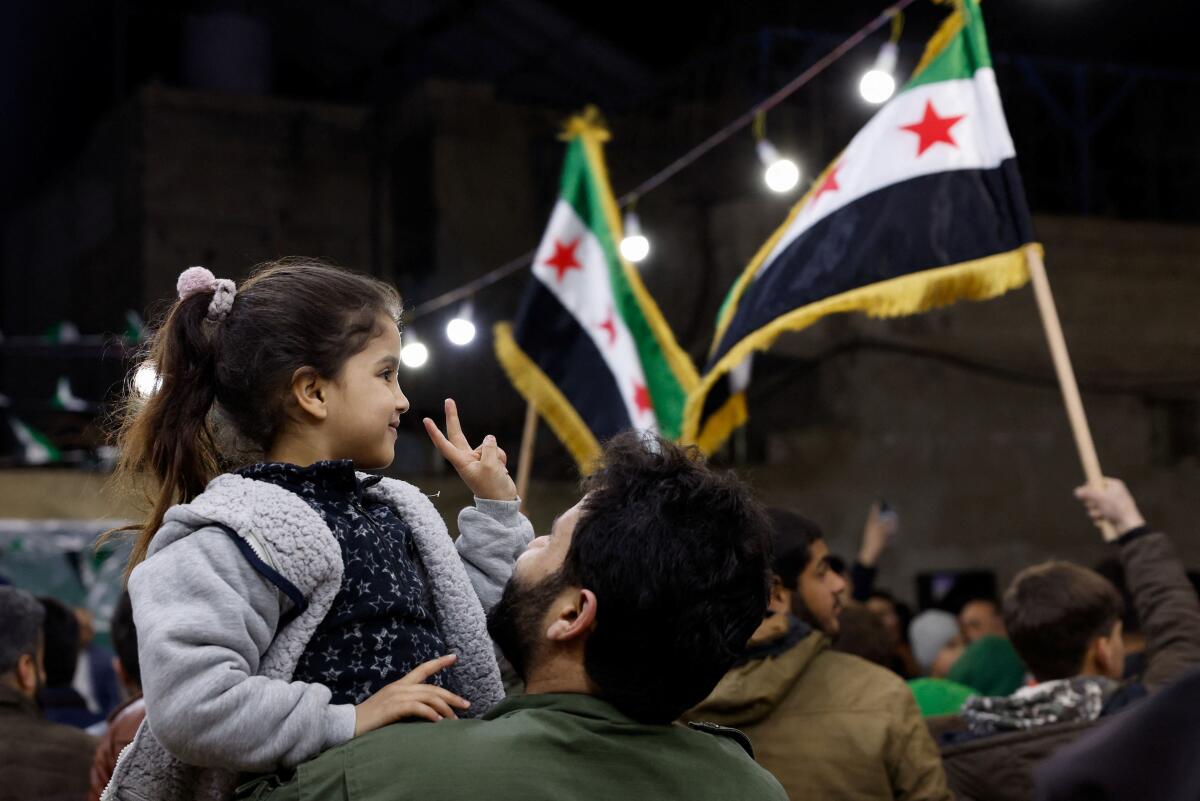 A girl shows a peace sign, as Syrians gather to mark the anniversary of the 2011 uprising against the ousted President Bashar al-Assad in Damascus, Syria March 15, 2026.