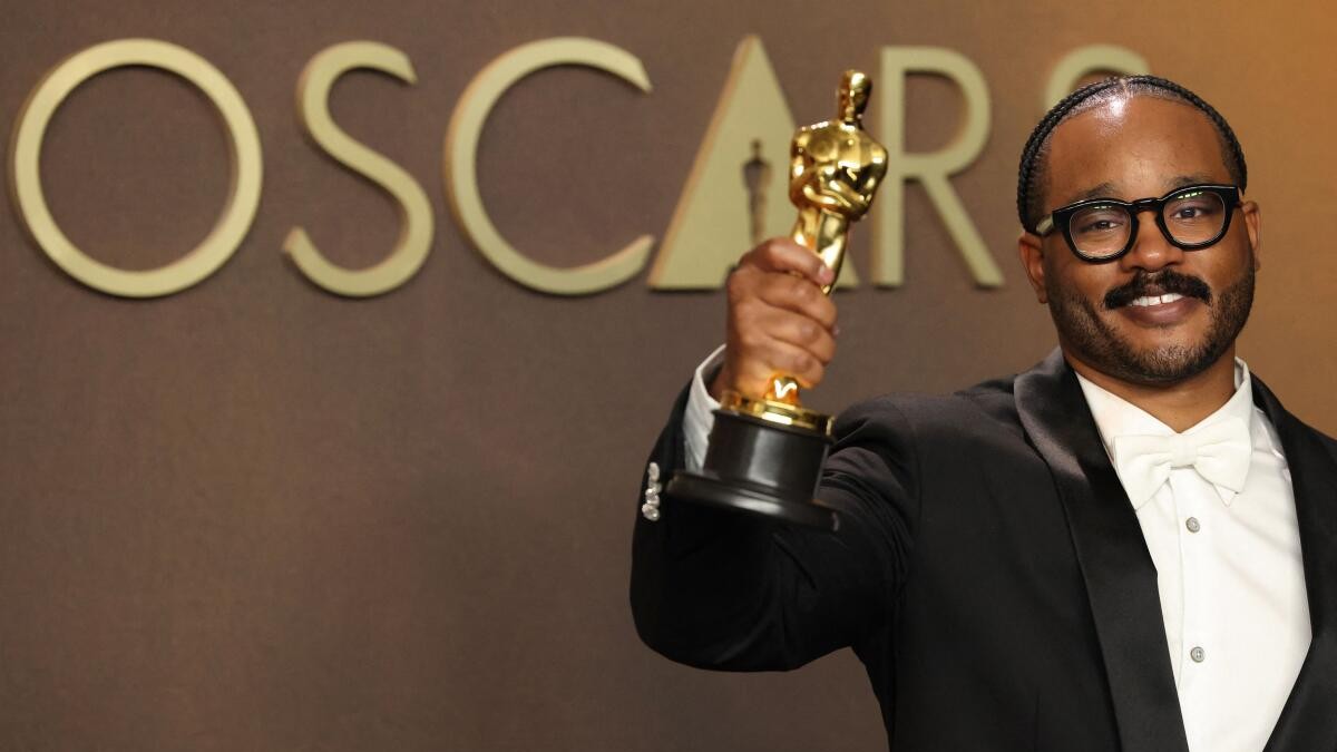 Ryan Coogler poses with the Oscar for Best Original Screenplay for Sinners.