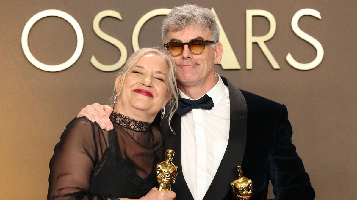 Tamara Deverell and Shane Vieau pose with the Oscar for Best Production Design for Frankenstein.
