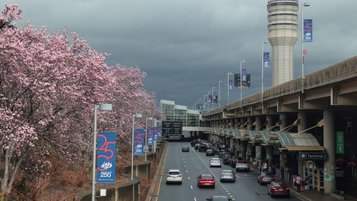 The air traffic control tower at Ronald Reagan Washington National Airport rises above the arrivals pick-up area and blossoming trees, as the Department of Homeland Security (DHS) continues to go unfunded, in Arlington, Virginia, US, March 16, 2026.