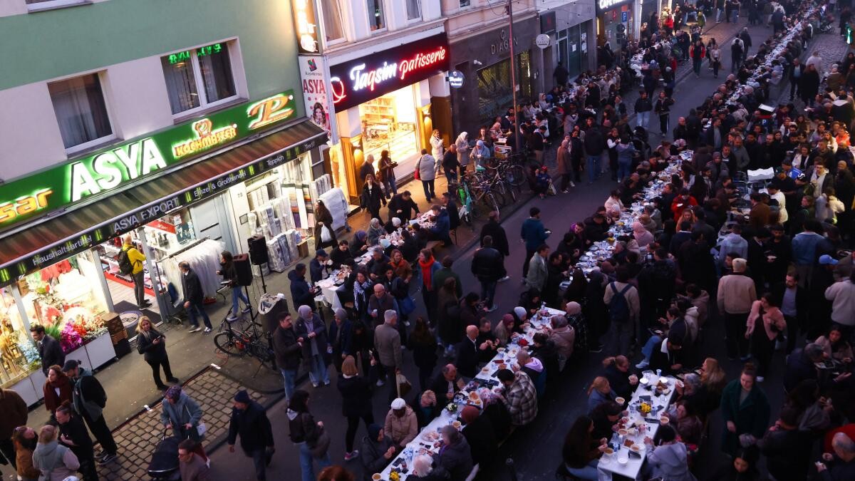Muslim worshippers and guests eat an iftar meal, the breaking of the fast, at a 300-metre-long table on Cologne's Keupstrasse to mark the end of the Holy Month of Ramadan, in Cologne, Germany, March 18, 2026.
