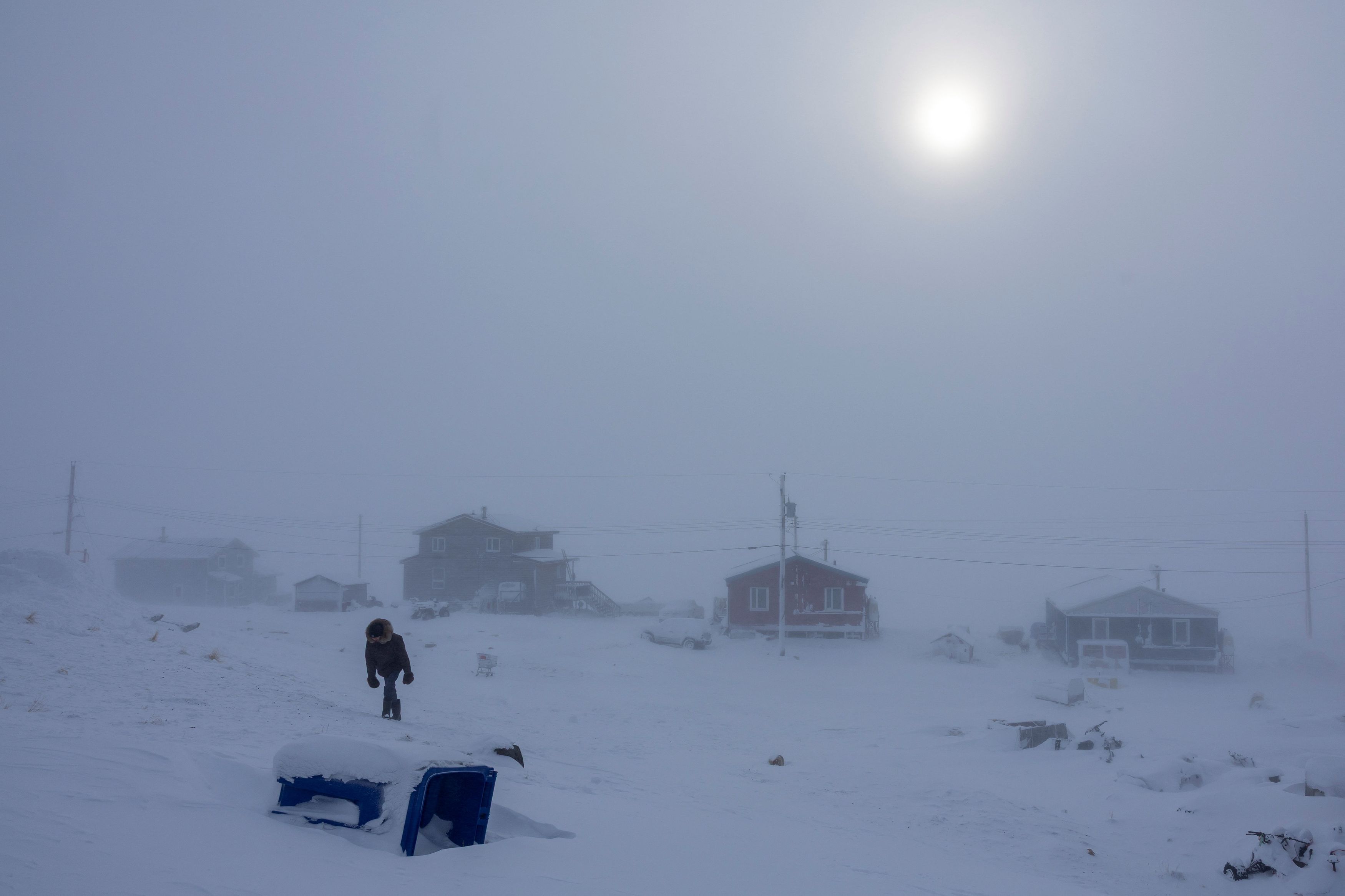 A person walks through blizzard conditions as Environment Canada issued a Yellow Warning with temperature dropping to -26 degrees Celsius, in Cambridge Bay, Nunavut, Canada