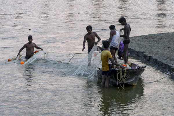 People catch fish in the Ganga river, in Prayagraj, Uttar Pradesh.