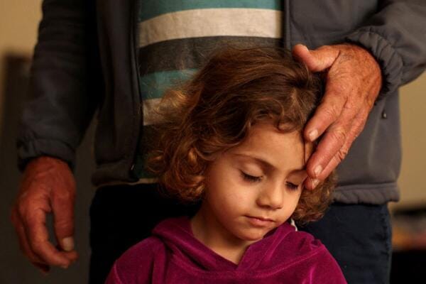 Mustafa Ibrahim al-Sayyed, 50, displaced from Beit Lif, caresses his daughter in a school now used as a temporary shelter for displaced people, amid escalating hostilities between Israel and Hezbollah, as the US.-Israel conflict with Iran continues, in Tyre, Lebanon.