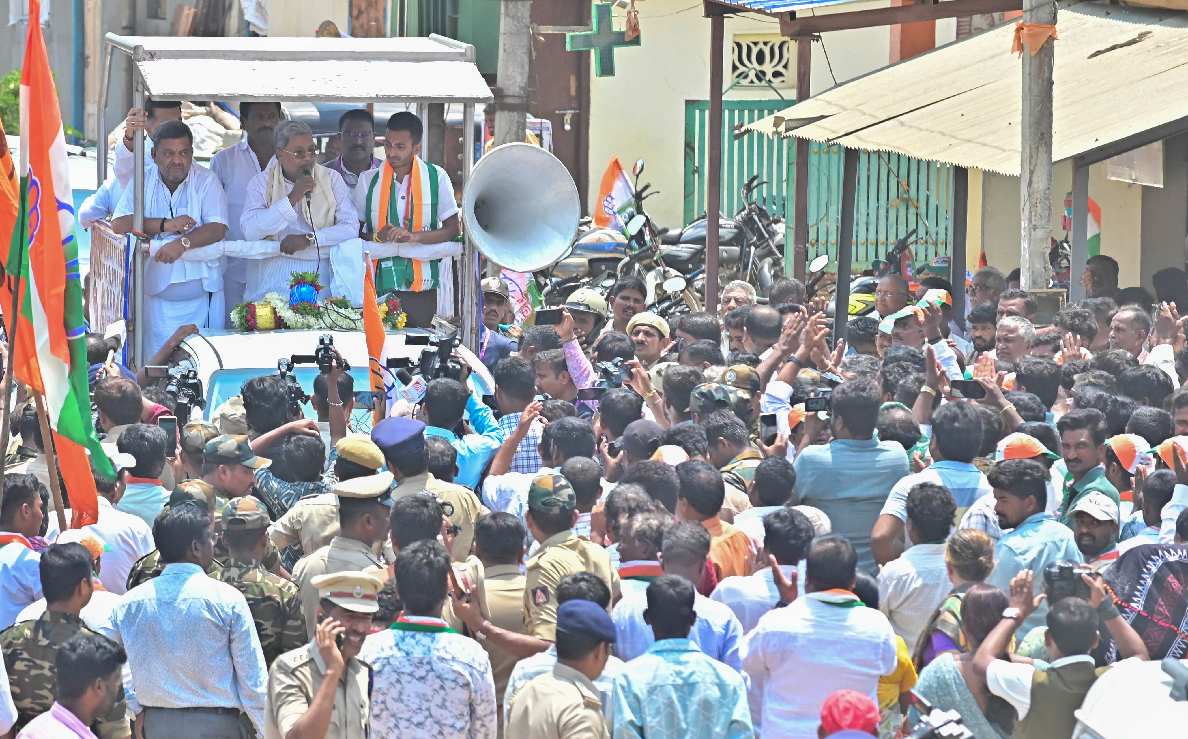Chief Minister Siddaramaiah flanked by minister S S Mallikarjun and his son and candidate from Davangere South Samarth Shamanur speaks during a road show at Naganur on Wednesday. 