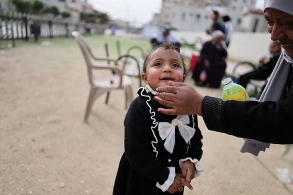Areej Ghanem (50), cleans the face of Tia Ghanem (3), at a playground in the neighbourhood where the Ghanem family rent a room in Tulkarm in the Israeli‑occupied West Bank, February 13, 2026. The family was displaced last year from the Tulkarm refugee camp.
