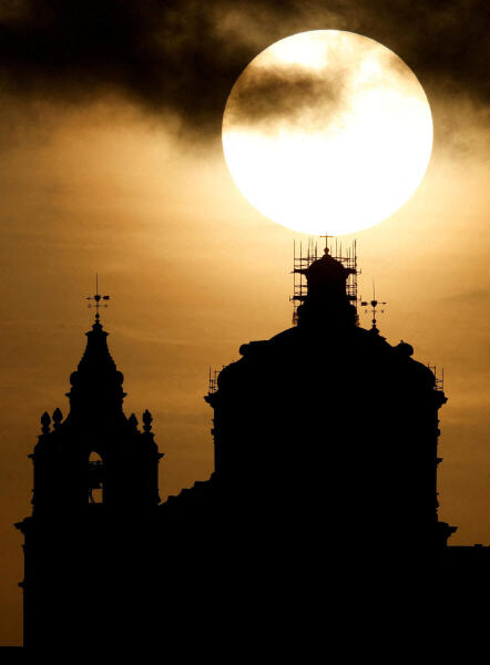 The sun sets behind behind St Paul's Metropolitan Cathedral in the medieval city of Mdina, Malta.