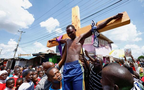 Kenyan Catholic devotee James Odawo, 21, portrays Jesus Christ in a re-enactment of his crucifixion, during a Good Friday procession in Kibera settlement of Nairobi, Kenya.
