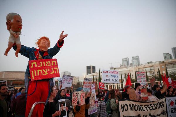 A demonstrator wears a mask depicting U.S. President Donald Trump while holding a puppet of a baby with a mask depicting Israeli Prime Minister Benjamin Netanyahu during an anti-war protest calling for an end to the U.S.-Israel conflict with Iran, in Tel Aviv, Israel.