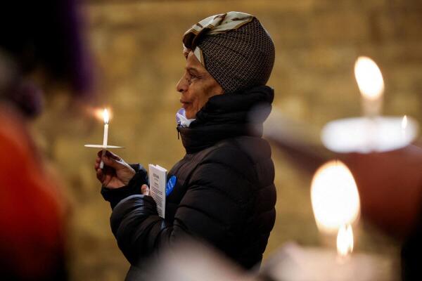A worshipper holds a lit candle as they attend the Easter Vigil Service at Southwark Cathedral, in London, Britain.