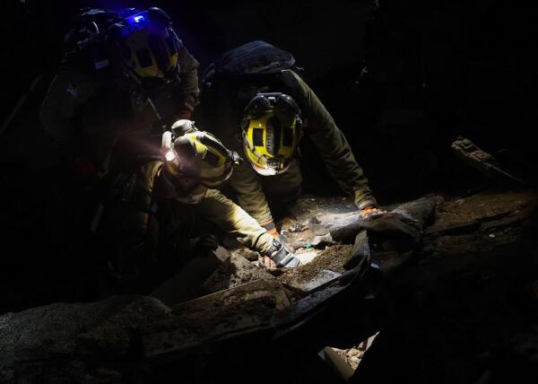 First responders work at the site of a missile strike, as the US-Israeli conflict with Iran continues, in northern Israel.