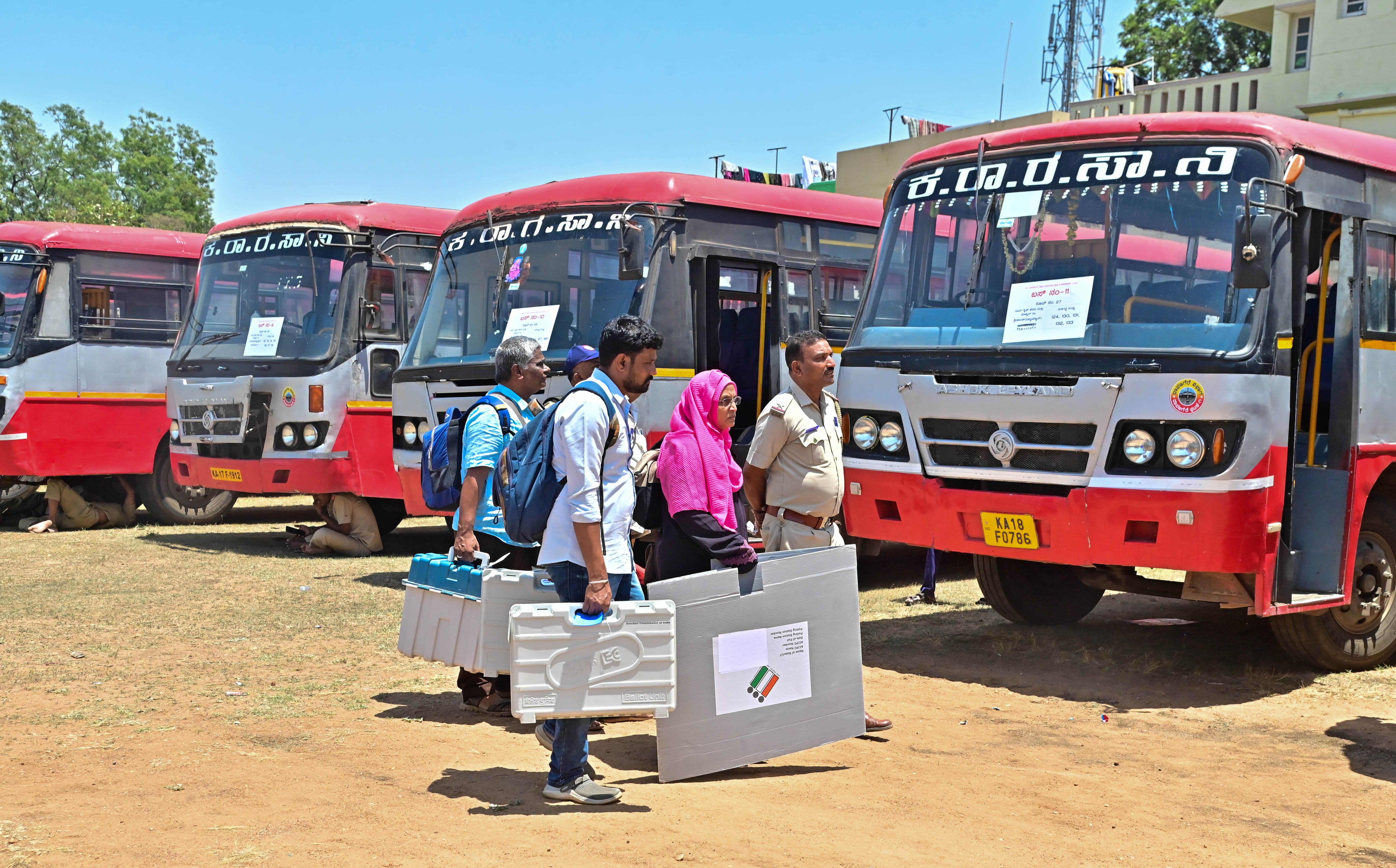 Personnel deputed for byelection duty board buses to their respective polling stations in Davangere on Wednesday. 