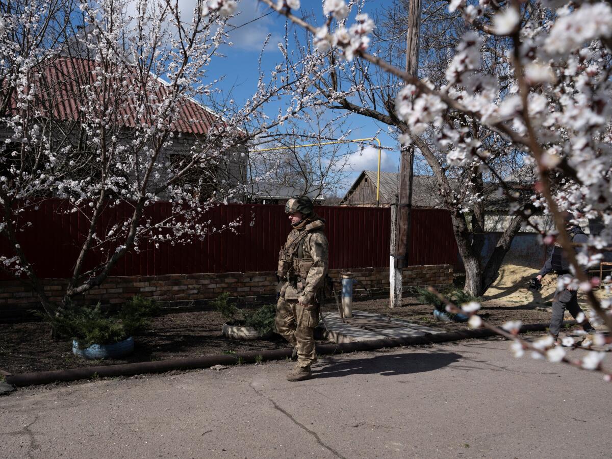 A Ukrainian soldier walks along a street on the outskirts of a front-line town of Druzhkivka.