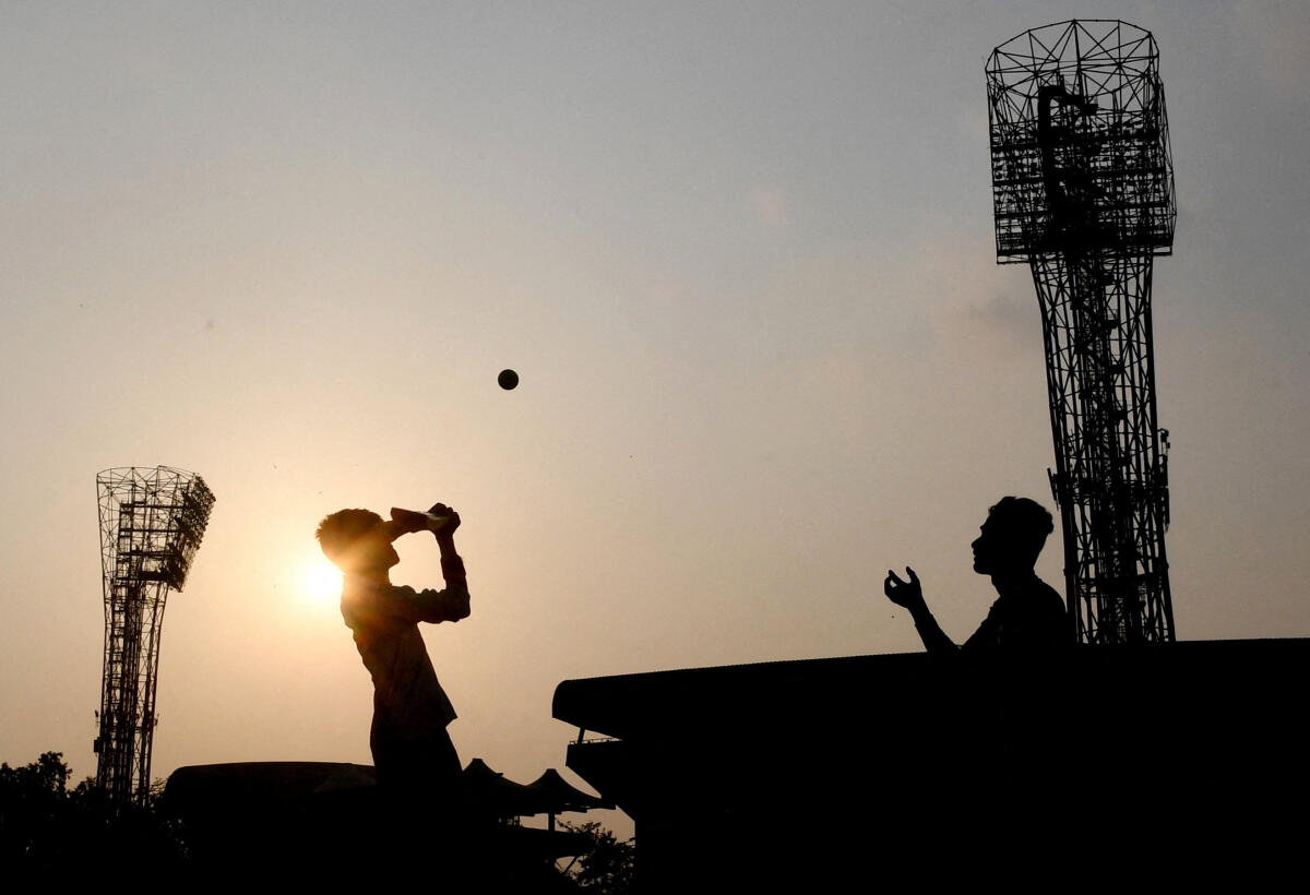 Fans play cricket outside the stadium.