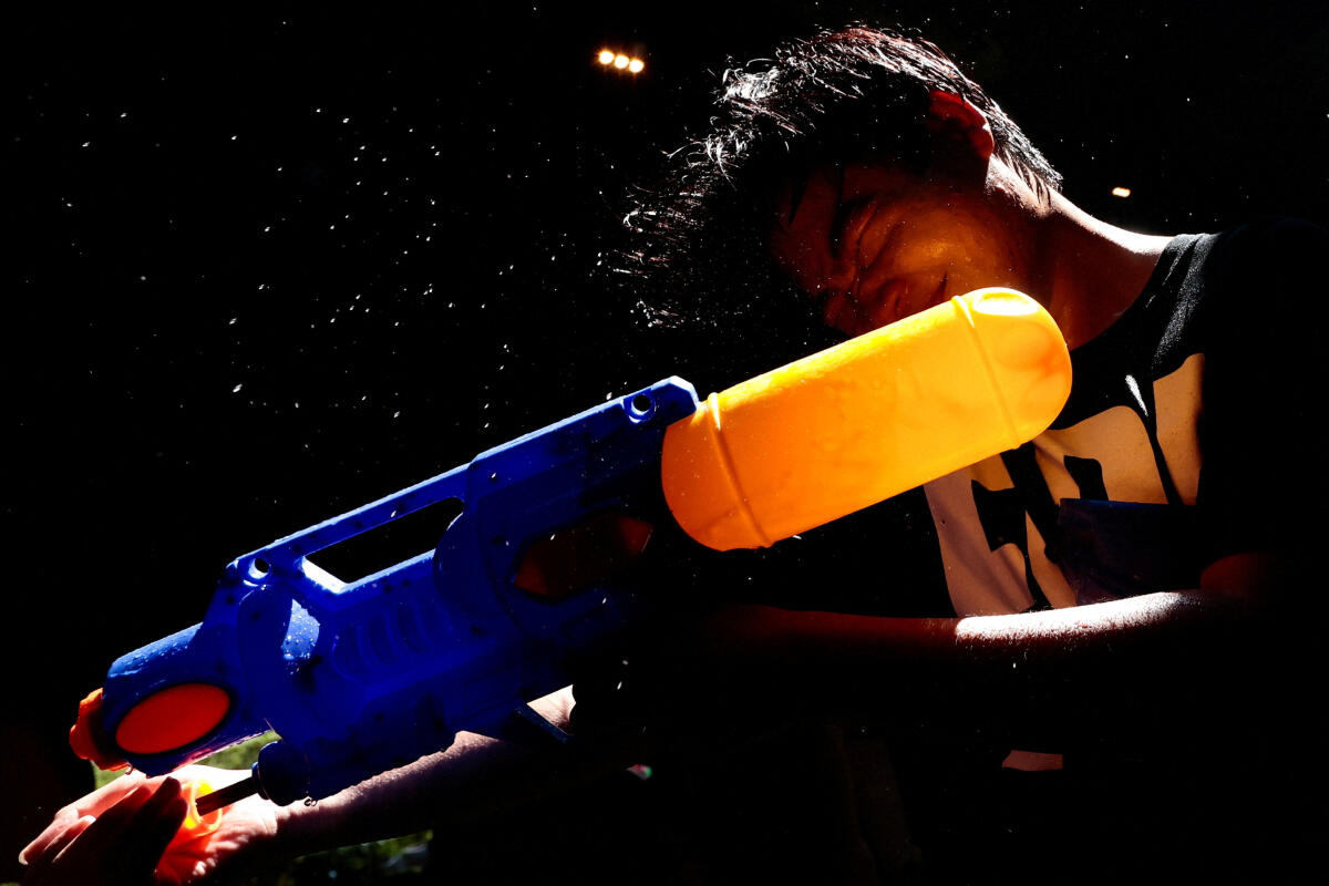 A reveller plays with water as he celebrates the Songkran holiday, which marks the Thai New Year, in Bangkok, Thailand