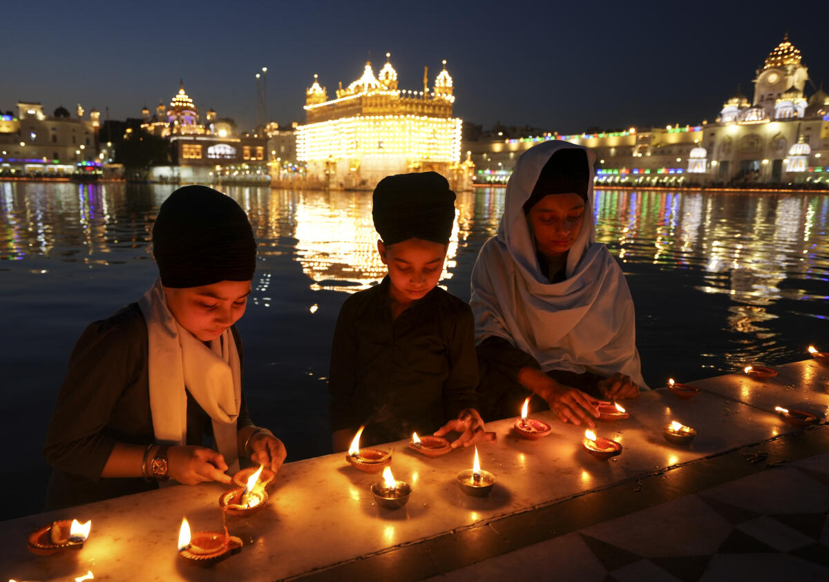 Devotees light earthen lamps on the occasion of the ‘Baisakhi’ festival at the Golden Temple in Amritsar on Tuesday. PTI