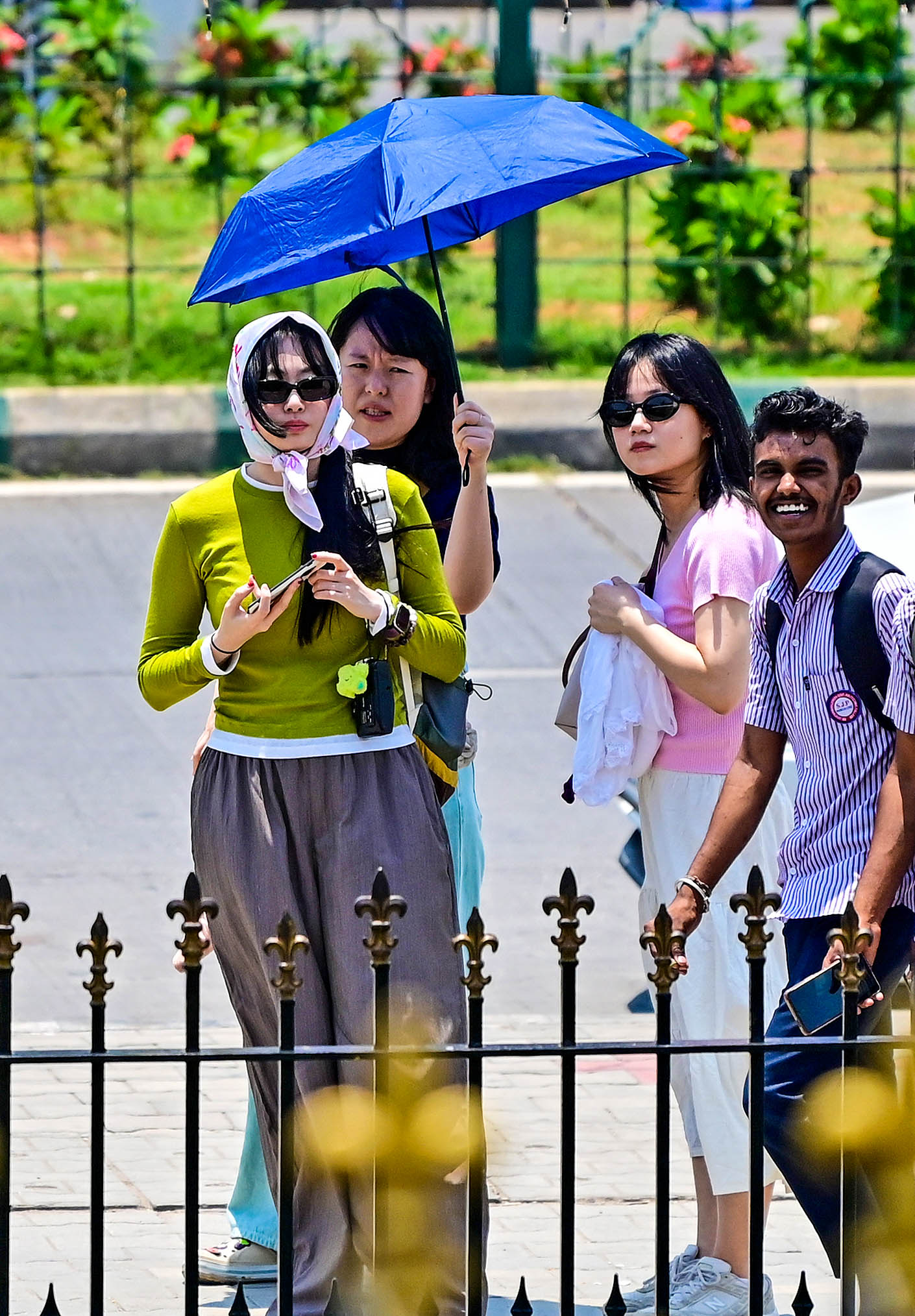 Umbrellas up as soaring temperatures drive visitors to seek shade outside the Vidhana Soudha on Tuesday. DH PHOTO/Ranju P