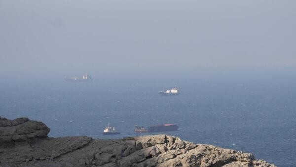 Iran navy warns ships to turn back in Strait of Hormuz, vessels hit by gunfire