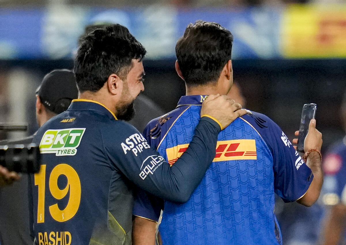 Mumbai Indians' team owner, manager Akash Ambani takes a selfie with Gujarat Titans' Rashid Khan after his team's win during the Indian Premier League (IPL) 2026 T20 cricket match.