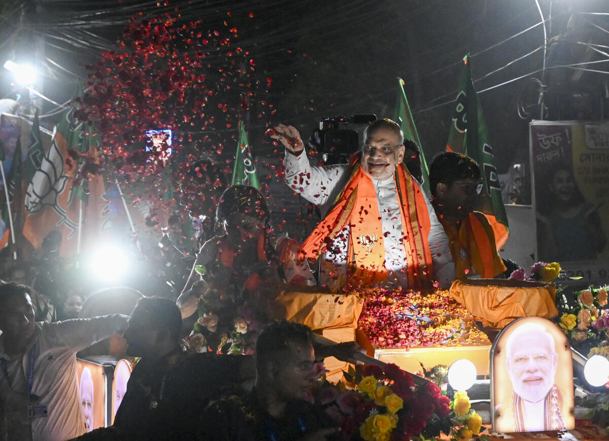 Union Home Minister Amit Shah greets supporters during a roadshow on the eve of the West Bengal Assembly elections, at Rajpur Sonarpur, in South 24 Parganas district.