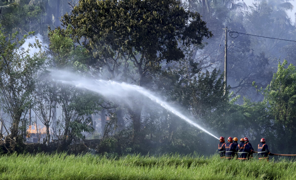 Fire and rescue personnel douse flames after a fire broke out at a fireworks manufacturing unit at Mundathikode village, in Thrissur district.