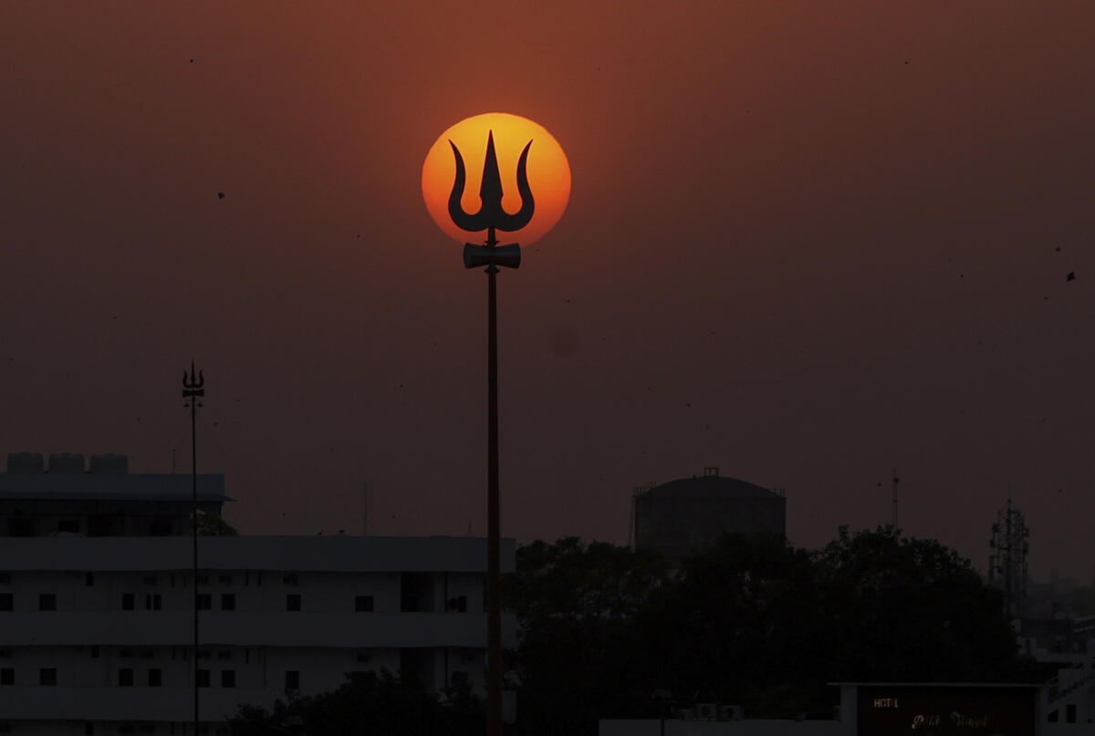 A trident is silhouetted against the setting sun, in Prayagraj.