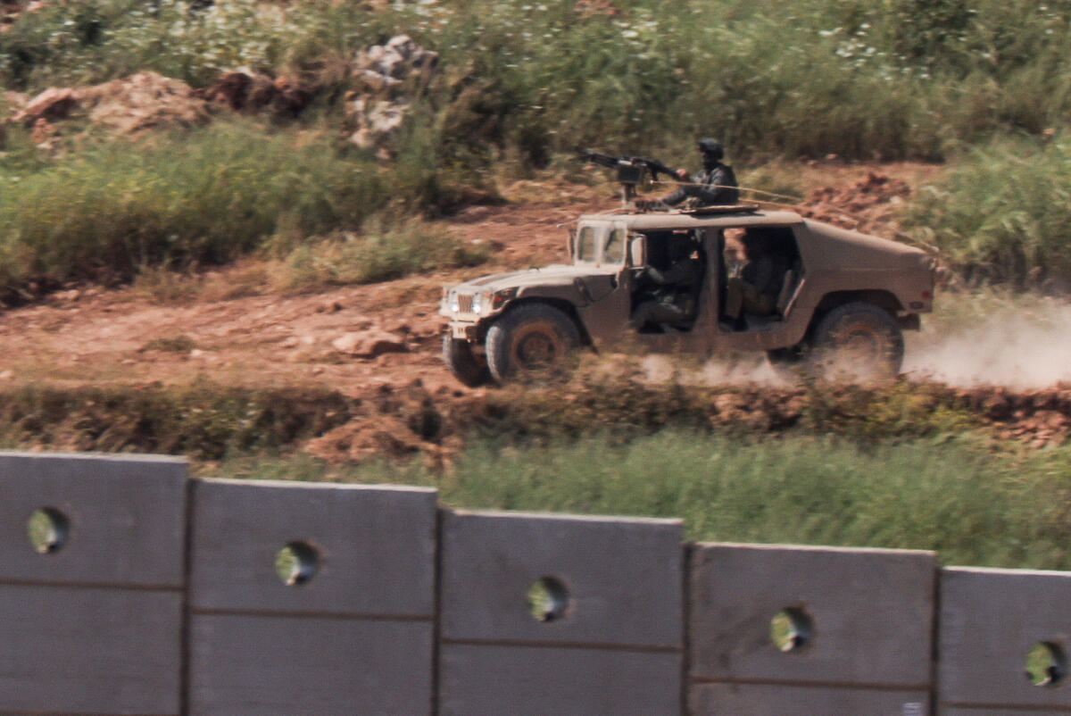 An Israeli armoured vehicle drives inside Lebanon, as seen from the Israeli side of the border with Lebanon