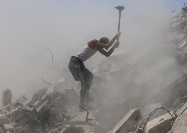 A Palestinian worker breaks up concrete while working on rubble in Khan Younis, southern Gaza Strip, April 19, 2026.
