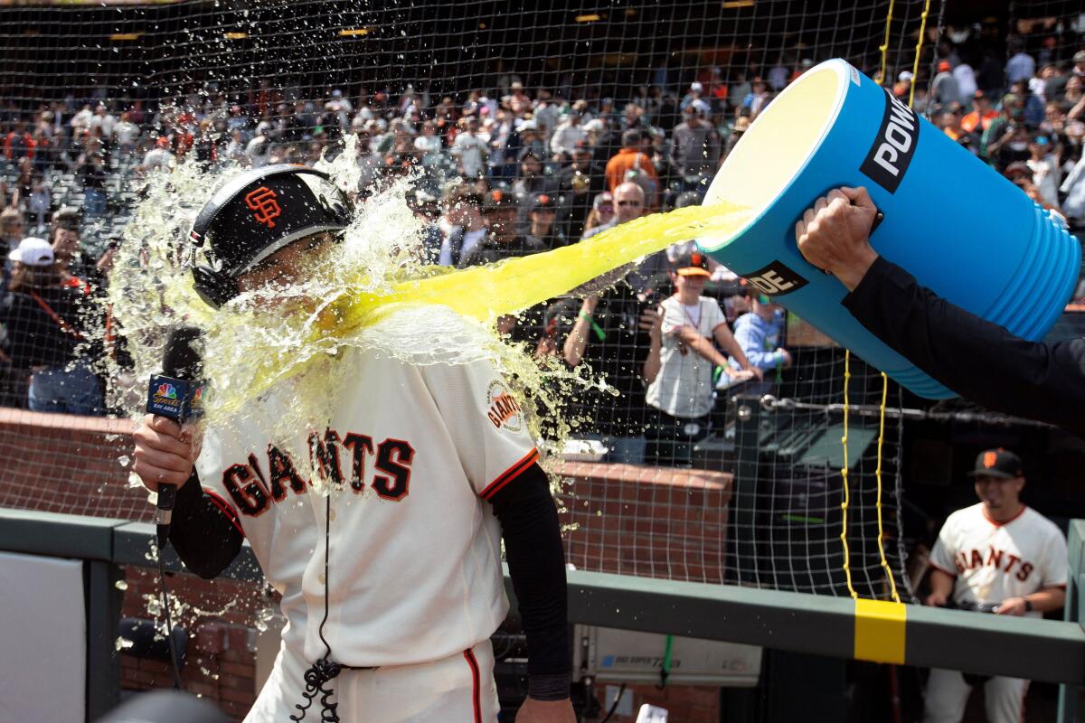 San Francisco Giants right fielder Jung Hoo Lee (51) get doused during a postgame interview following a 6-3 victory over the Miami Marlins at Oracle Park.
