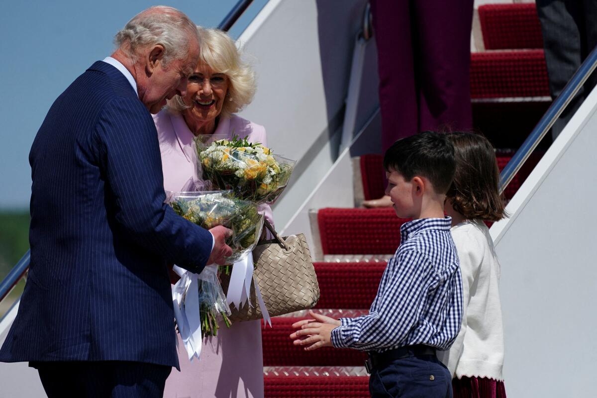 Britain's King Charles and Queen Camilla are welcomed by children with flowers after they disembarked the plane on arrival for a state visit to the United States at Joint Base Andrews, Maryland, U.S., April 27, 2026.
