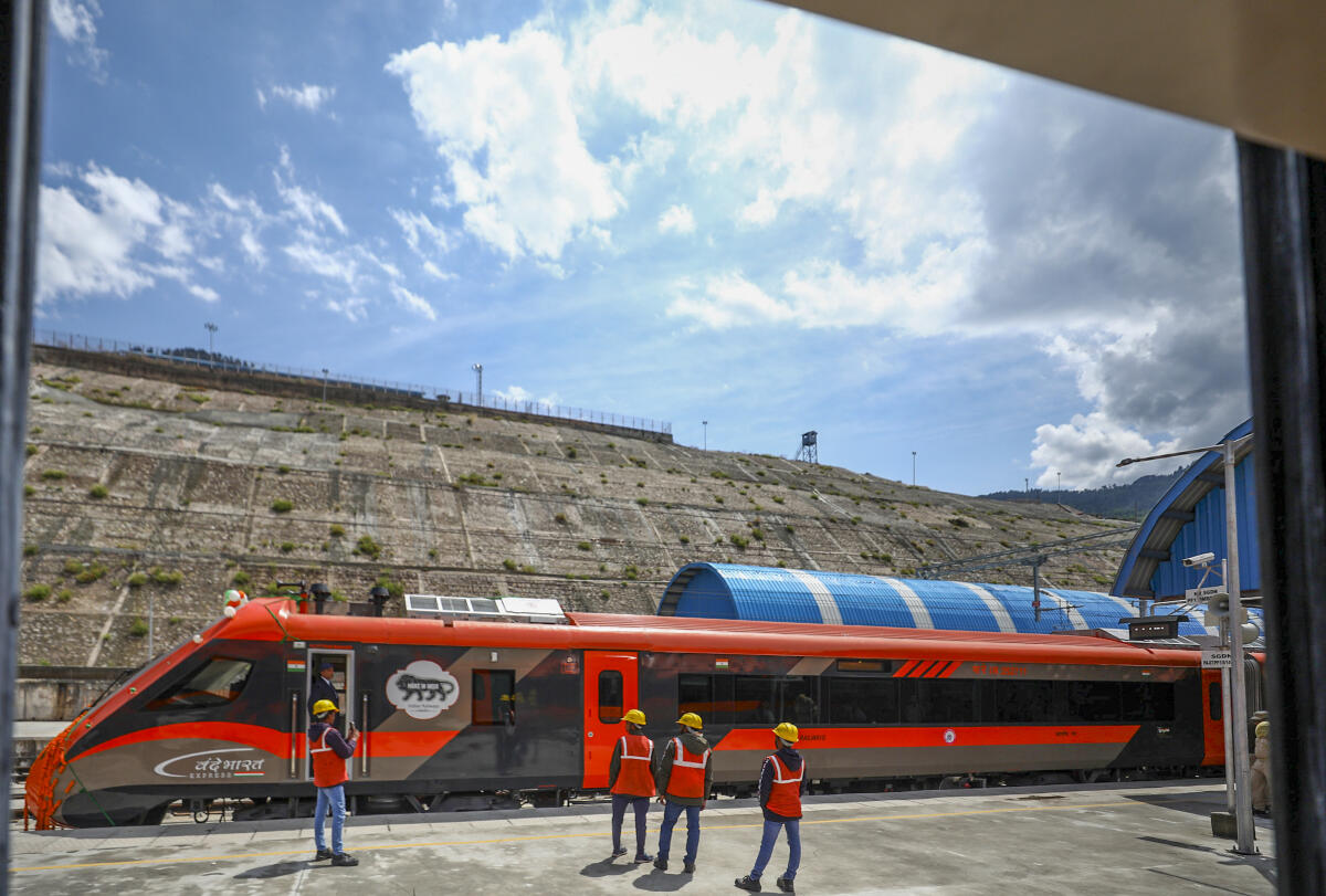Workers take pictures at a platform during the launch of direct Vande Bharat Express train service between Jammu and Srinagar, near Sangaldan Railway station, in Ramban district, Thursday, April 30, 2026.