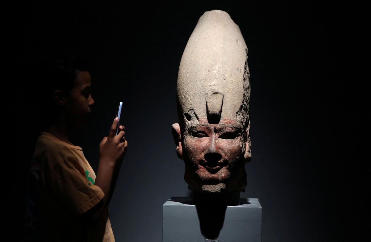 A boy takes picture inside the Luxor Museum, in Luxor, Egypt.