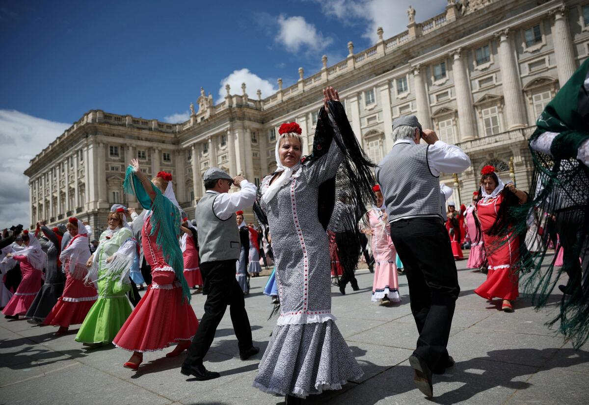 People dressed in traditional chulapo attire dance outside the Royal Palace during San Isidro festivities, Madrid’s annual patron saint celebrations, in Madrid, Spain.