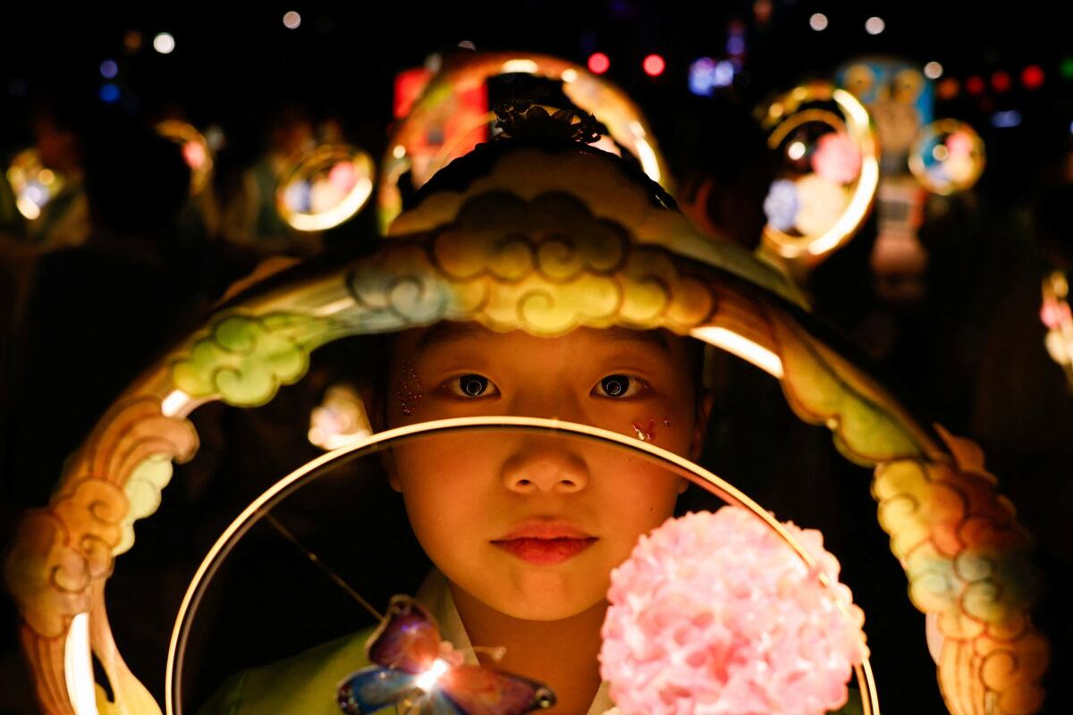 A girl carrying a lantern takes part in a Lotus Lantern parade ahead of Vesak Day, the birthday of Buddha, in Seoul, South Korea.