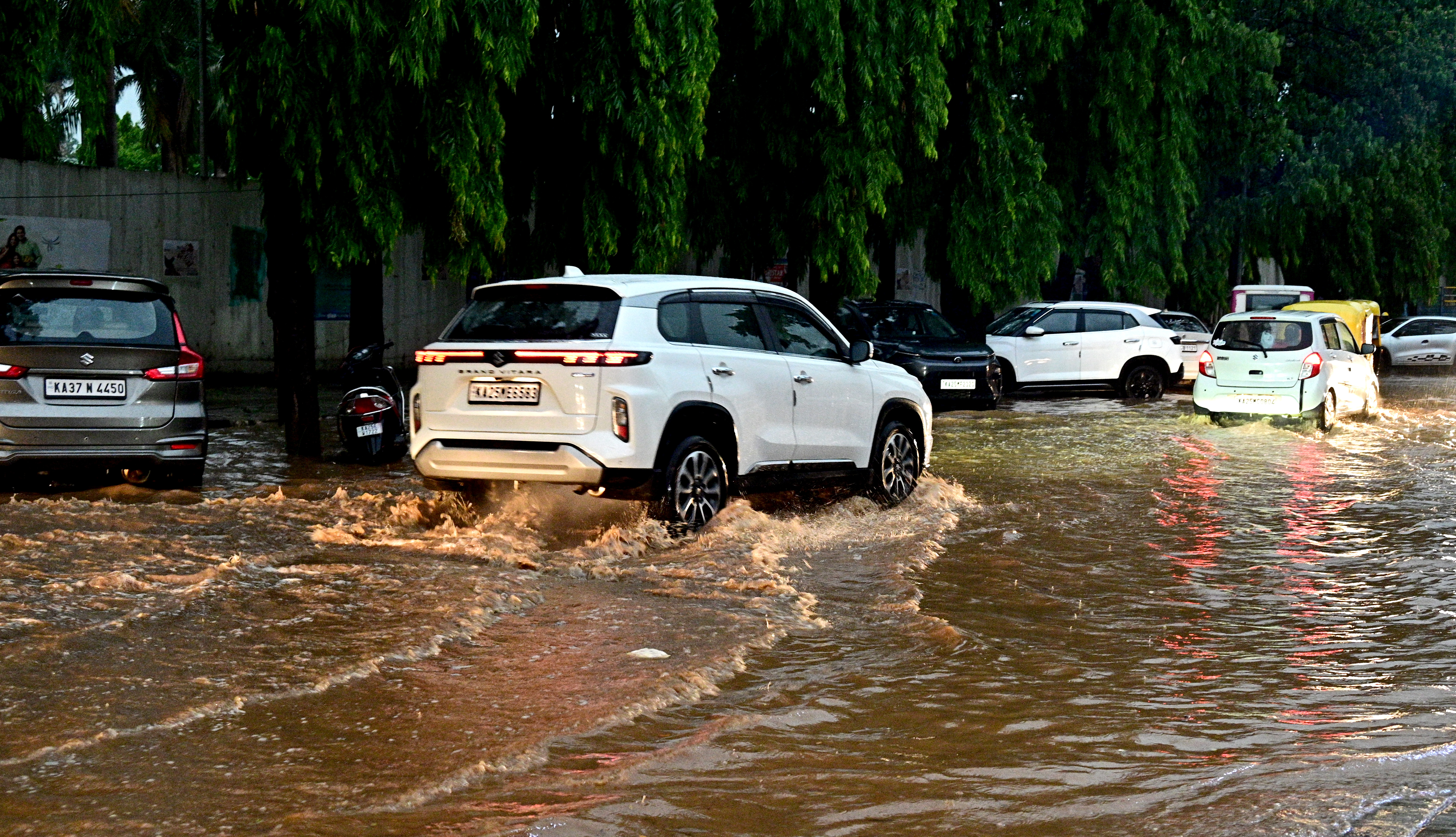 Motor vehicles navigate a flooded Indira Glass House Road in Hubballi on Sunday.